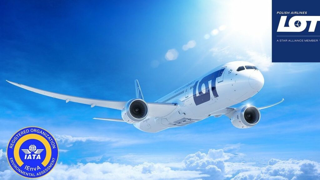 A LOT Polish Airlines airplane flies through a bright blue sky.